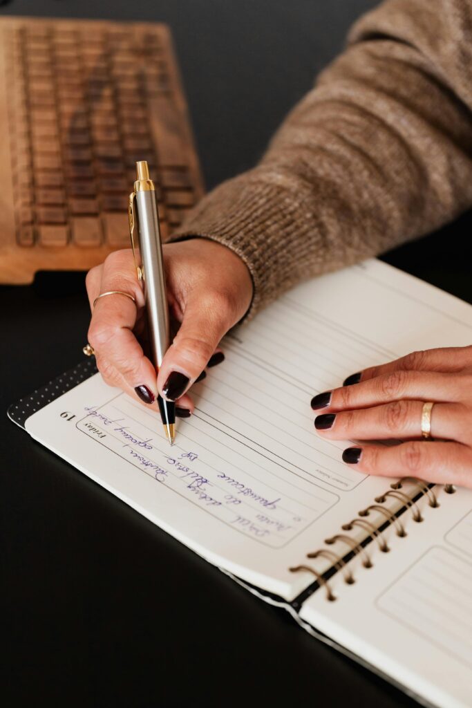 A photo of a woman handwriting in a notebook